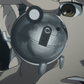 Close-up of a metal Upa with a Mayuri's face reflected on it.